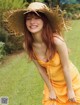 A woman in a yellow dress and a straw hat.