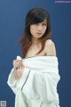 A woman wrapped in a white towel posing for a picture.