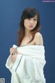 A woman wrapped in a white towel posing for a picture.