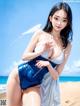 A woman in a blue and white bathing suit on the beach.