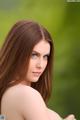 A woman with long brown hair and blue eyes posing for a picture.