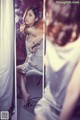 A woman sitting on a chair in front of a mirror.