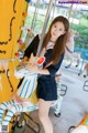 A woman in a school uniform is posing on a carousel.