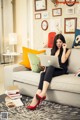 A woman sitting on a couch using a laptop computer.