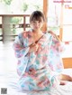 A woman in a kimono sitting on a bed.