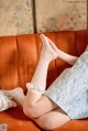 A woman sitting on a couch with her legs crossed.