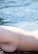 A woman laying on the beach next to the water.