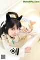 A woman in a bathtub with a cat ears headband.