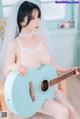 A woman in a wedding dress playing a guitar.