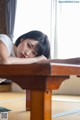 A woman laying on the floor next to a table.