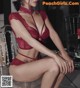 A woman in a red lingerie sitting on a chair.