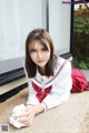 A woman in a school uniform laying on the ground.