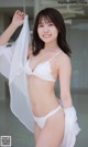 A woman in a white lingerie posing for a picture.