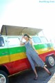 A woman standing in front of a colorful van.