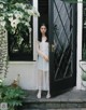 A woman standing in front of a black door.