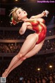 A woman in a red and gold leotard flying through the air in front of a crowd.