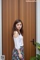 A woman standing in front of a wooden door.