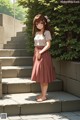 A girl in a pink skirt standing on some steps.