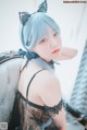 A woman with blue hair wearing a black lingerie.